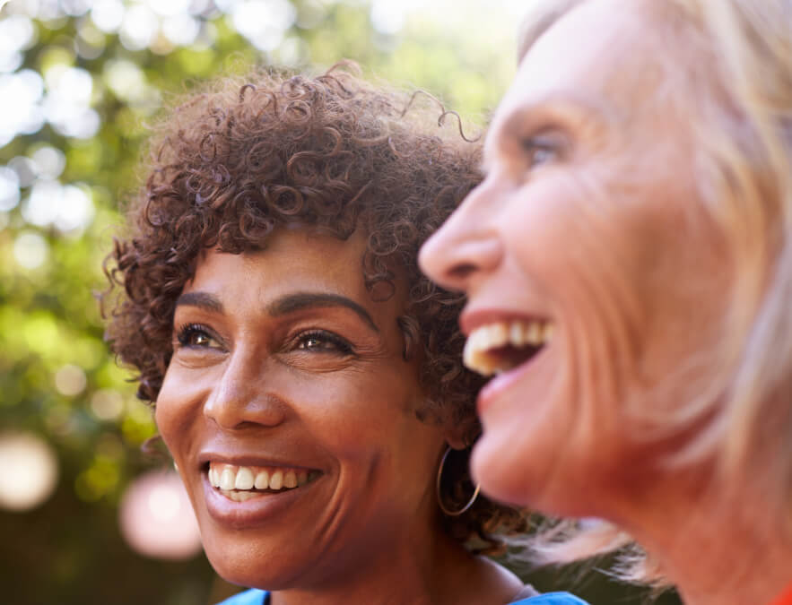 Two smiling elderly women outdoors