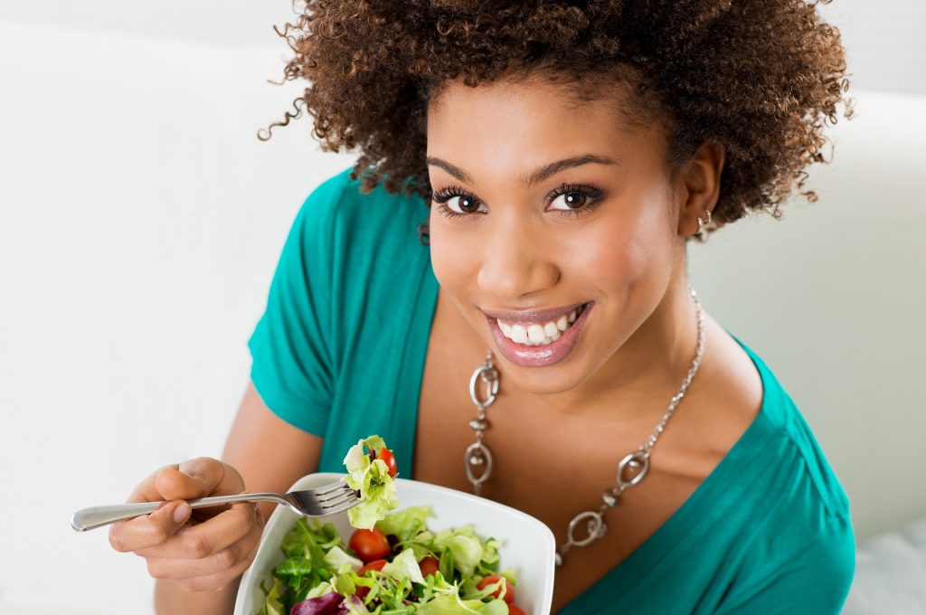 Smiling woman eating a salad